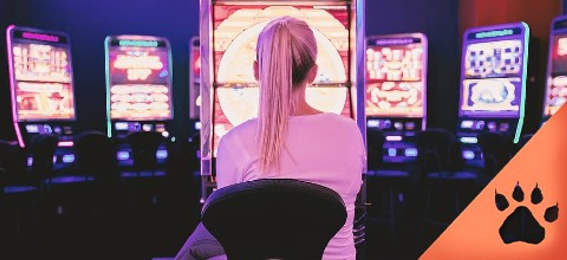 Donna seduta di fronte a una slot machine in un casinò.